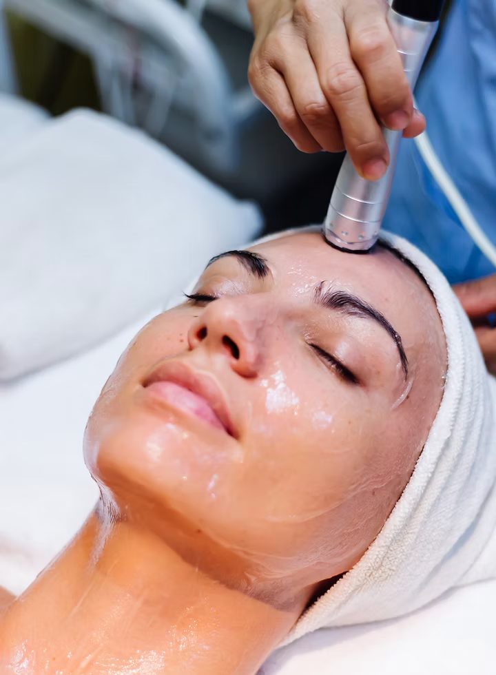 A facial in progress, product being worked over the cheekbone.